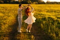 Cheerful young couple in love dancing together on green meadow in summer evening during golden sunset with soft sunlight Royalty Free Stock Photo