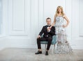 Cheerful young couple in luxury fashionable clothes posing indoors