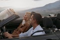 Cheerful young couple man and woman in cabriolet car holding hands feeling happy Royalty Free Stock Photo