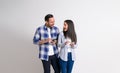 Cheerful young couple with mobile phones looking at each other excitedly against white background Royalty Free Stock Photo