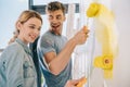 Cheerful young couple painting wall in Royalty Free Stock Photo