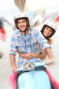 Cheerful young couple riding scooter Royalty Free Stock Photo