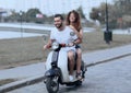 Happy cheerful couple riding vintage scooter. Travel concept. Royalty Free Stock Photo