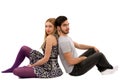 Cheerful young couple sitting with back to each other on floor, Royalty Free Stock Photo