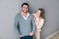 Cheerful young couple standing on grey background