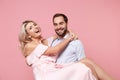 Cheerful young couple two guy girl in party outfit celebrating posing isolated on pastel pink background. People Royalty Free Stock Photo