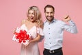 Cheerful young couple two guy girl in party outfit celebrating posing isolated on pastel pink background. Valentine`s Royalty Free Stock Photo