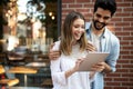Cheerful happy couple using digital tablet outdoors Royalty Free Stock Photo