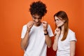 cheerful young couple in white t-shirts chatting orange background Royalty Free Stock Photo
