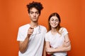 cheerful young couple in white t-shirts chatting orange background Royalty Free Stock Photo