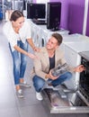 Cheerful young customers choosing new dish washing machine Royalty Free Stock Photo