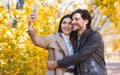 Cheerful young embraced couple taking selfie outdoors