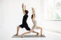 Cheerful young european guy and woman in sportswear do hand exercises, practice yoga on mat