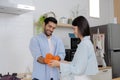 Cheerful young european lady and male washing dishes in modern kitchen interior. Hygiene, household chores in spare time. Young