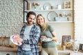 Cheerful young european lady and male washing dishes in modern kitchen interior. Hygiene, household chores in spare time