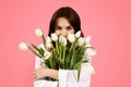 Cheerful young european lady smelling bouquet of flowers, enjoy lifestyle, aroma of tulips, rejoice spring