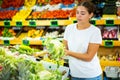 Cheerful young female buying cauliflower in hypermarket