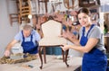 Smiling young female carpenter showing around local furniture workshop Royalty Free Stock Photo