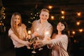Cheerful young friends are clinking glasses Champagne and holds Bengali lights Royalty Free Stock Photo