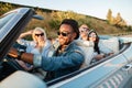 Cheerful young friends driving car and smiling in summer Royalty Free Stock Photo