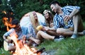 Cheerful young friends having fun by campfire Royalty Free Stock Photo