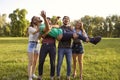 Cheerful young friends having fun in countryside on summer day. Group of people laughing and being silly in nature