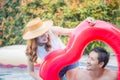 Cheerful young friends having fun in heart shaped inflatable, Happy young couple having fun at swimming pool. Happiness lifestyle Royalty Free Stock Photo