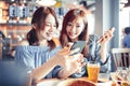 Cheerful young friends looking at smart phone in restaurant Royalty Free Stock Photo