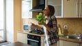 Cheerful young funny woman dancing and singing with lettuce microphone while cooking breakfast Royalty Free Stock Photo