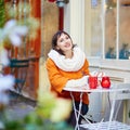 Cheerful young girl in Parisian outdoor cafe