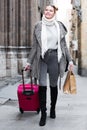 Cheerful young girl in scarf with baggage