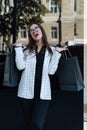 Cheerful young girl shopper with packages after shopping. Black Friday. Shopping at bargain price. Vertical frame Royalty Free Stock Photo