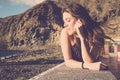 Cheerful young girl smile and enjoy the summer time laying outdoor in relax leisure activity - mountains and beach in background Royalty Free Stock Photo