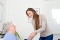 Cheerful young girl taking care of old senior woman at her home Royalty Free Stock Photo