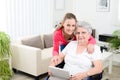 Cheerful young girl teaching internet with computer tablet and sharing time with an old senior woman on wheelchair Royalty Free Stock Photo