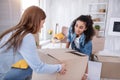 Cheerful young girls carrying heavy box together Royalty Free Stock Photo