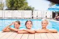 Cheerful young girls are swimming in blue water