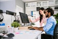 The cheerful young group of Asian businessmen in casual with an Indian one sitting and Asian businesswoman colleagues discussing Royalty Free Stock Photo