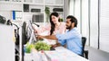 The cheerful young group of Asian businessmen in casual with an Indian one sitting and Asian businesswoman colleagues discussing Royalty Free Stock Photo