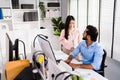 The cheerful young group of Asian businessmen in casual with an Indian one sitting and Asian businesswoman colleagues discussing Royalty Free Stock Photo