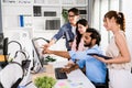 The cheerful young group of Asian businessmen in casual with an Indian one sitting and Asian businesswoman colleagues discussing Royalty Free Stock Photo