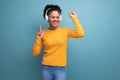 cheerful young hispanic business woman with black curly hair listening to music in white headphones Royalty Free Stock Photo