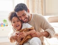 Cheerful young hispanic father tickling his daughter, playing with her. Excited parent bonding with his daughter at home