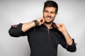 Cheerful young Hispanic male wearing a black shirt standing against a white wall Royalty Free Stock Photo