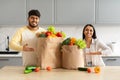 Cheerful young indian spouses with paper bags full of grocery Royalty Free Stock Photo