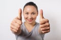 Cheerful young lady showing two thumbs up and looking at camera. Pretty woman recommending something. Recommendation concept, Royalty Free Stock Photo