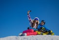Cheerful young loving couple making winter selfie on a mountain peak during a vacation on a ski resort. Royalty Free Stock Photo