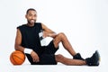 Cheerful young man basketball player sitting and drinking water Royalty Free Stock Photo