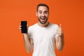 Cheerful young man in casual white t-shirt posing isolated on orange background in studio. People lifestyle concept Royalty Free Stock Photo