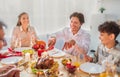 Cheerful young man celebrating Christmas or Thanksgiving at home, cutting roasted turkey for festive family dinner Royalty Free Stock Photo